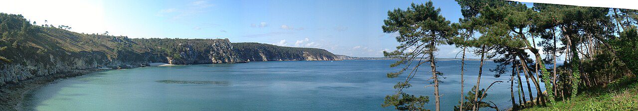 Vue plongeante sur la crique turquoise de l'Île Vierge depuis le sentier