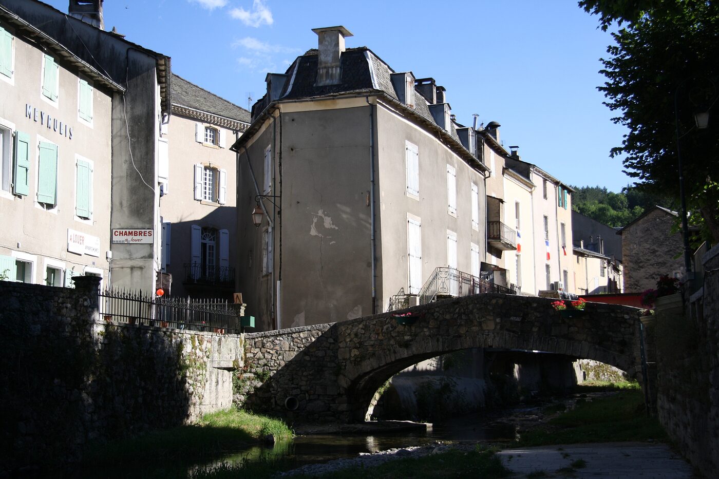Une ruelle de Meyrueis et son vieux pont de pierre au bord de la Jonte, en Lozère