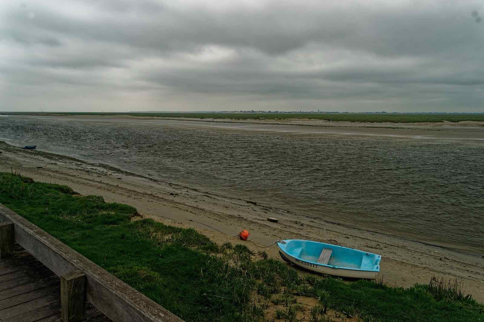 Vue depuis la rive de Saint-Valery-sur-Somme vers Le Crotoy, barque échouée, chenal et mollières à marée basse