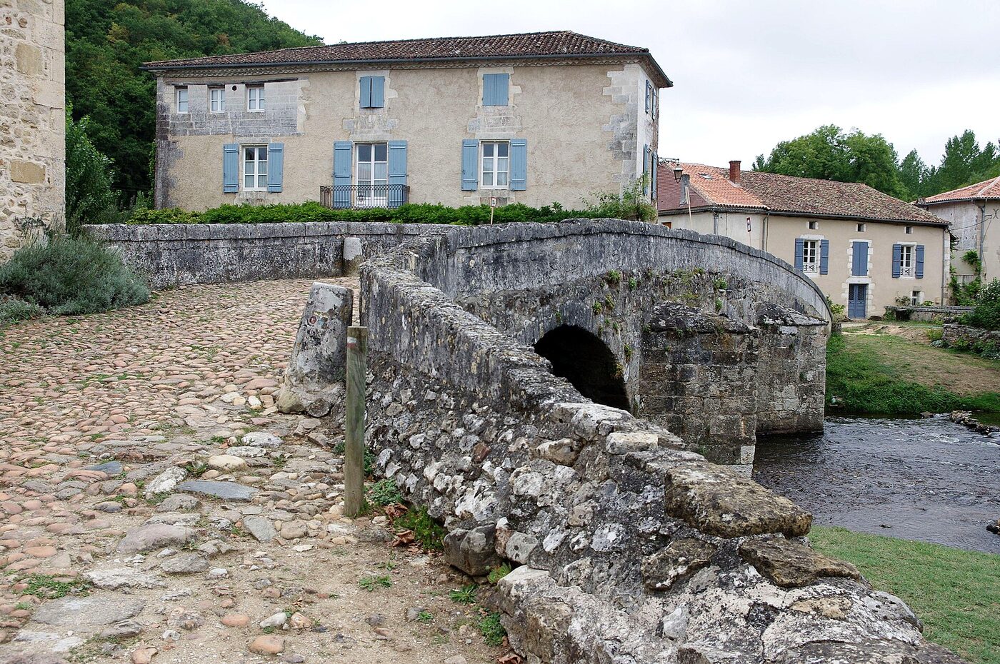 Le vieux pont médiéval de Saint-Jean-de-Côle enjambant la Côle, devant le prieuré