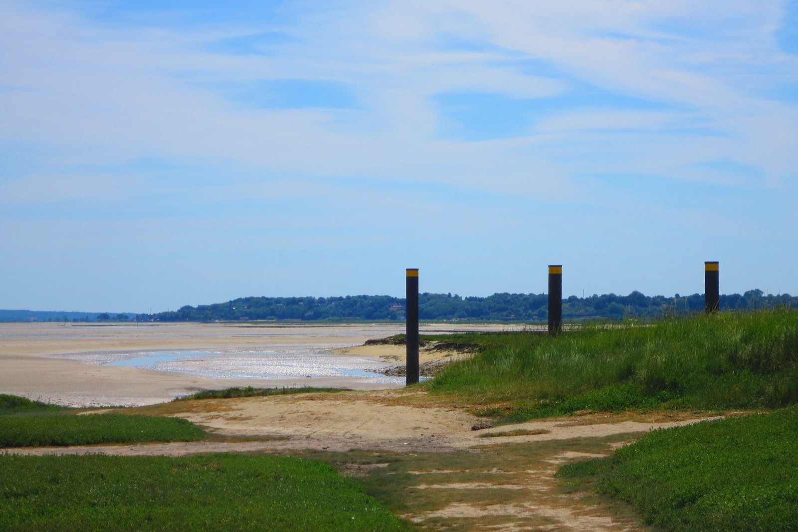 L'estran du Hourdel à marée basse en baie de Somme, avec les balises noires et jaunes du chenal